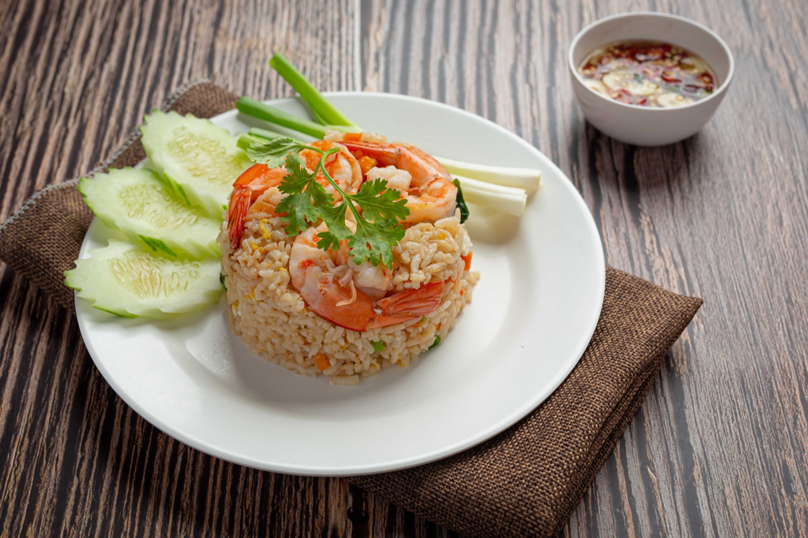 Shrimp fried rice served with cucumber and Thai chili fish sauce