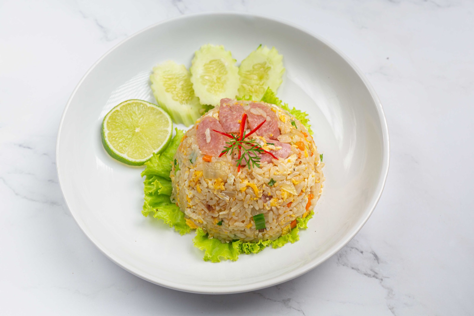 Thai fried rice with egg, vegetables, pork and fresh lime