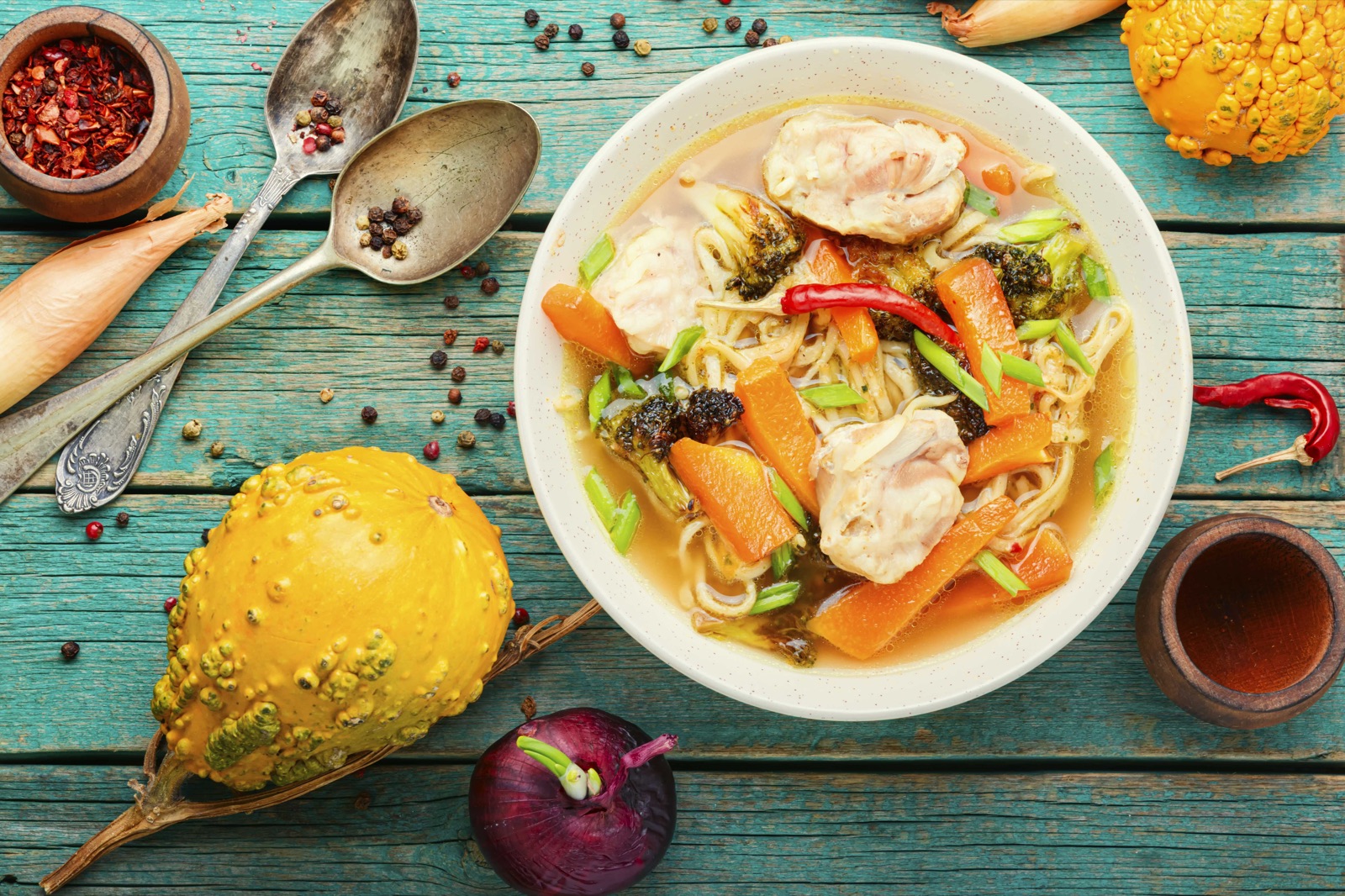 Thai chicken noodle soup with broccoli, carrots and scallions